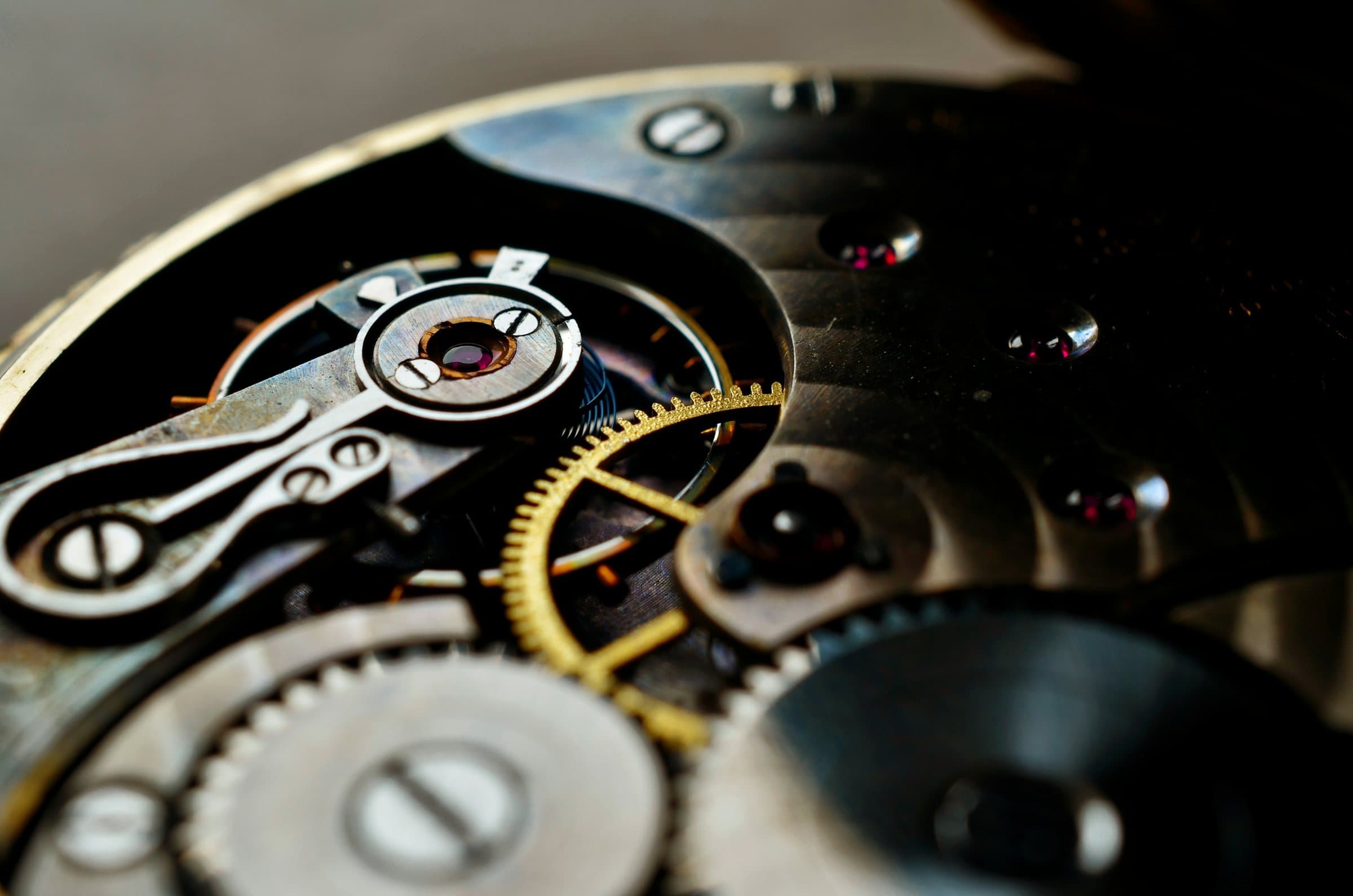 A mechanical watch movement in close-up, jewels and a gilded wheel.