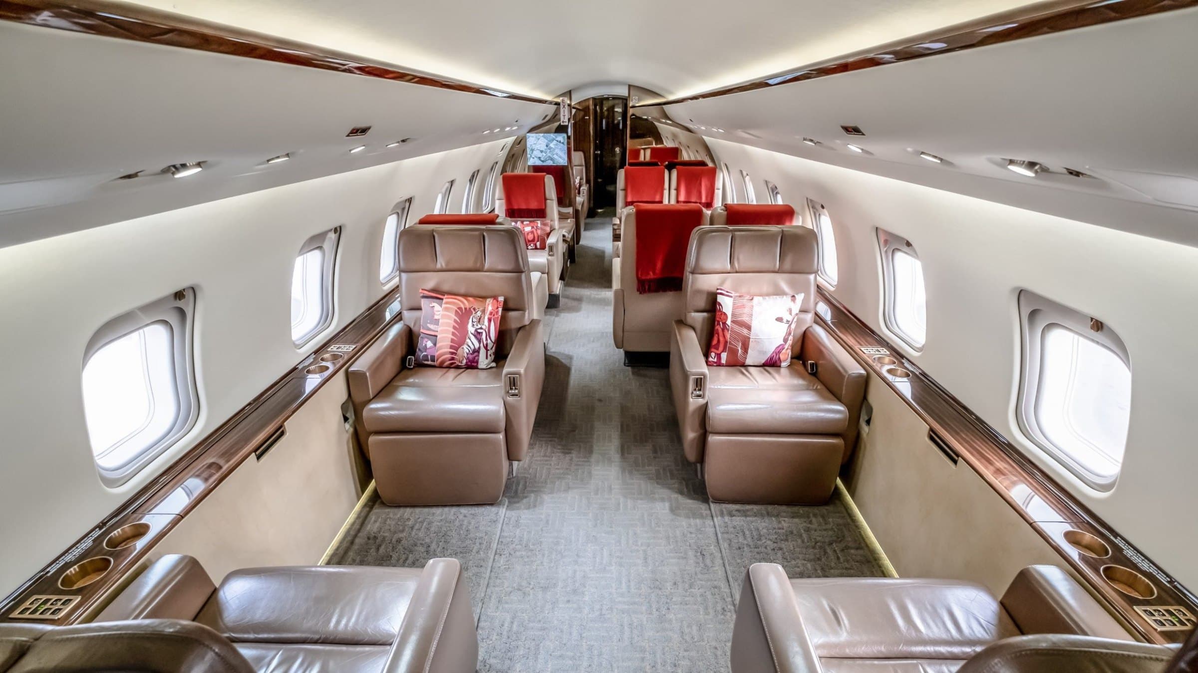 The cabin of a private jet, pale leather seats.