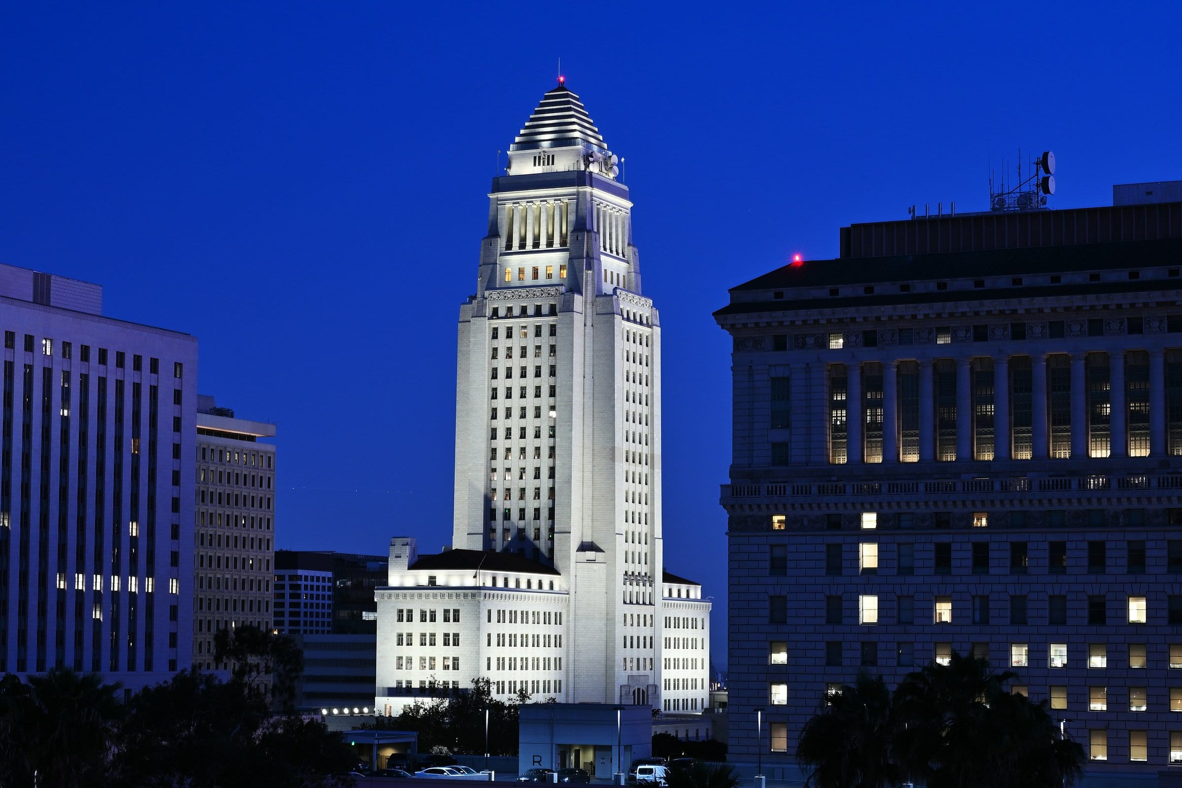 A Los Angeles tower lit against a deep blue-hour sky.