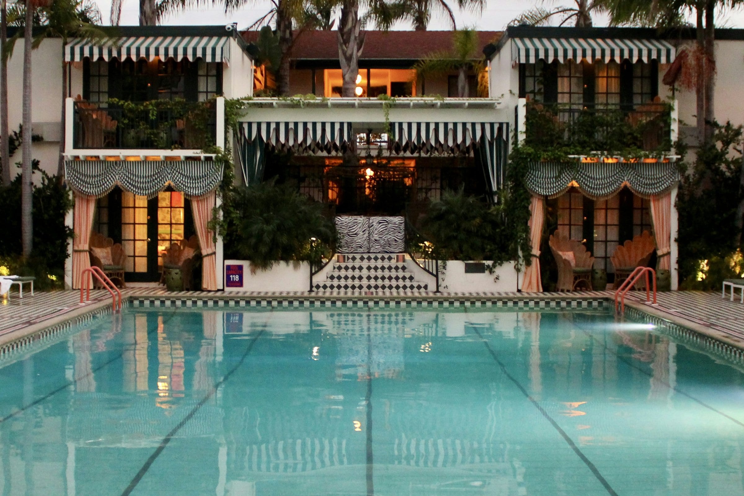 A Californian hotel pool at dusk, windows lit from within.