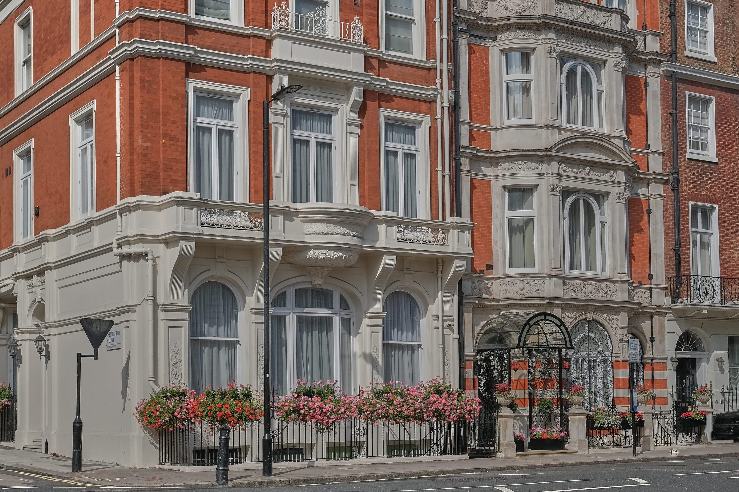 A Mayfair corner facade, red brick and dressed stone.