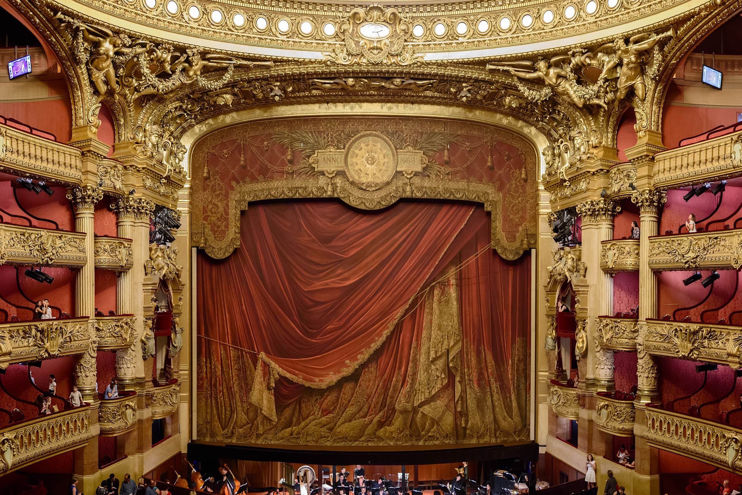 Sala a la italiana, palcos dorados superpuestos y telón de escena pintado.