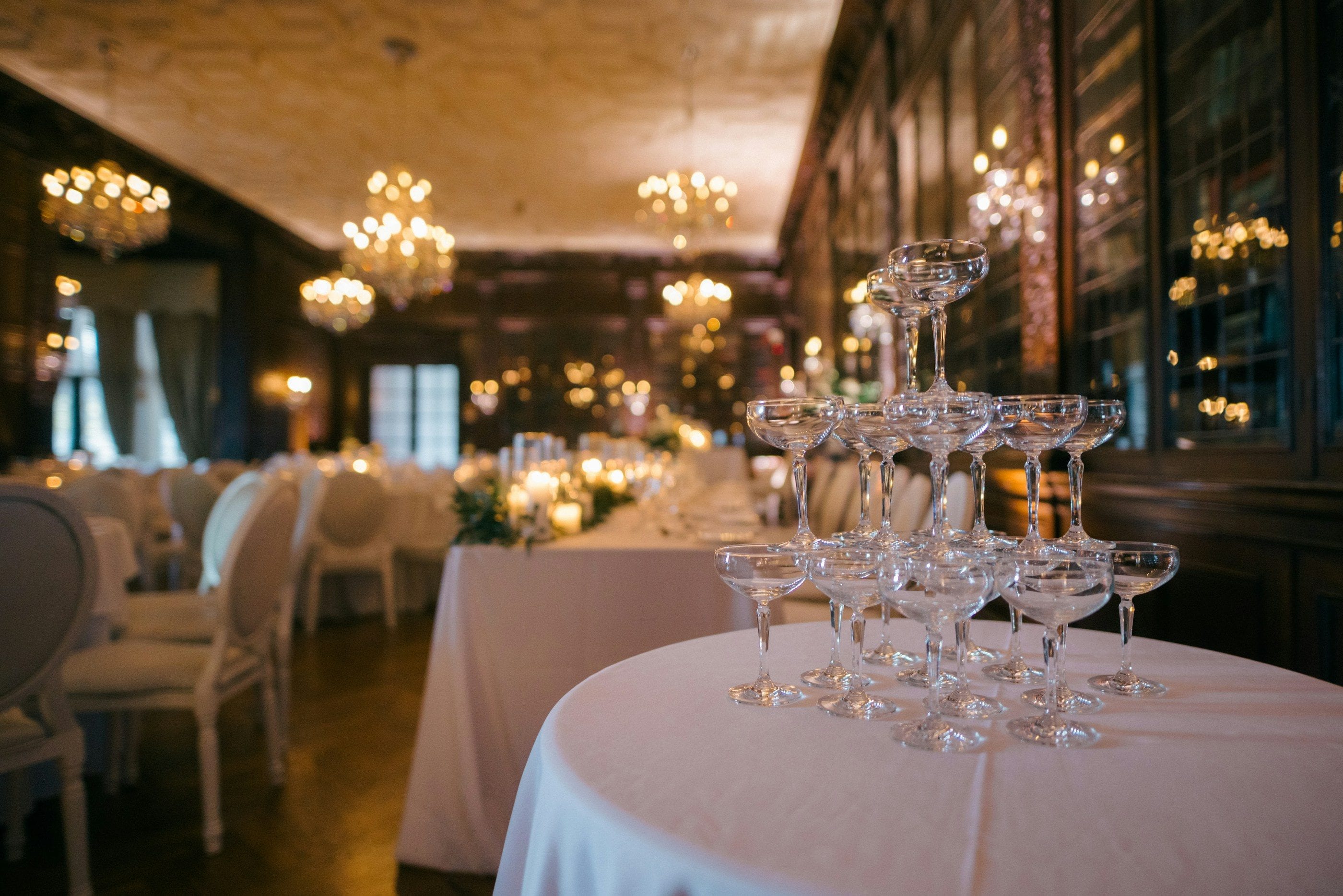 A reception room laid for dinner, a tower of coupes before the guests arrive.