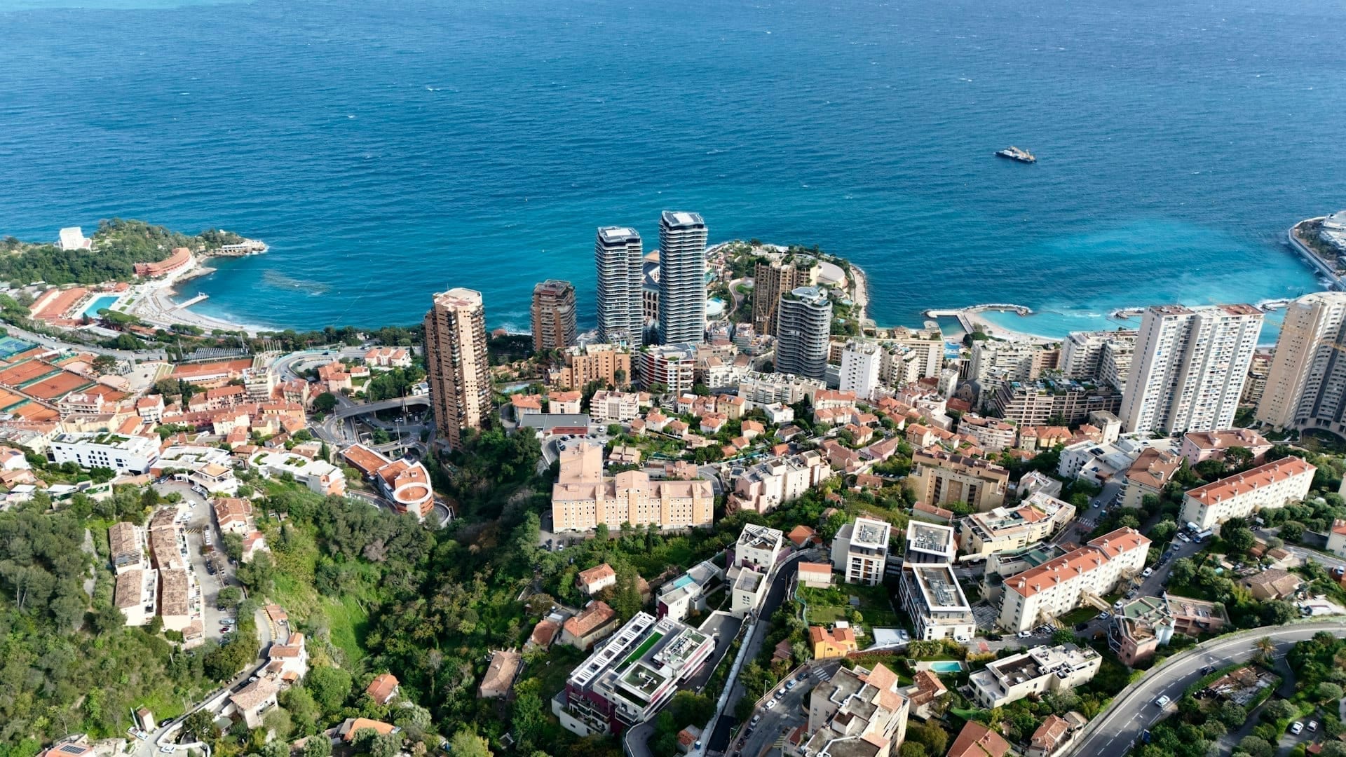 The Principality seen from above, buildings pressed between mountain and sea.