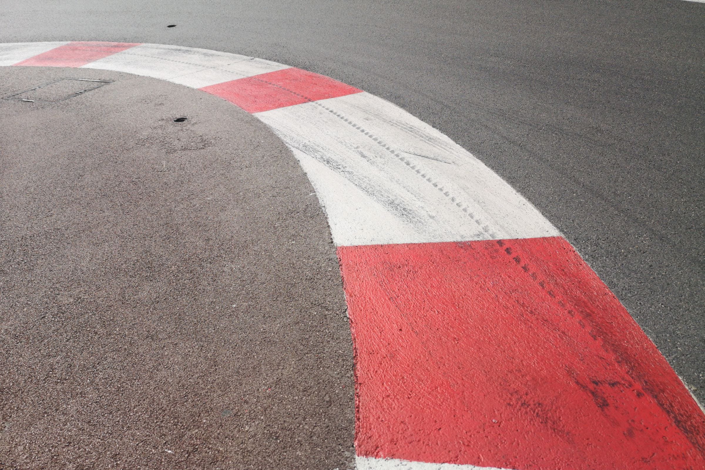 A red-and-white circuit kerb, scored by tyre rubber.