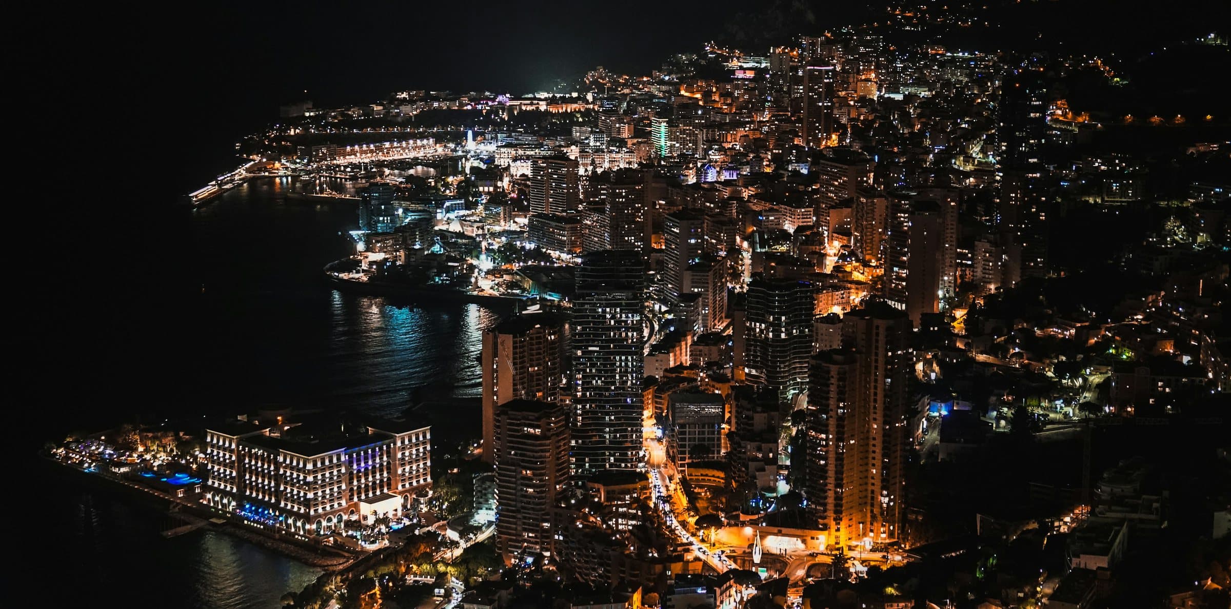 Monte-Carlo at night, the city lit along the coast.