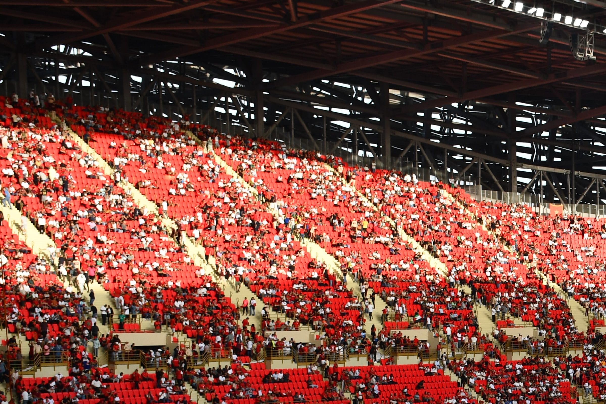 Packed stands on a match day, in full sun.