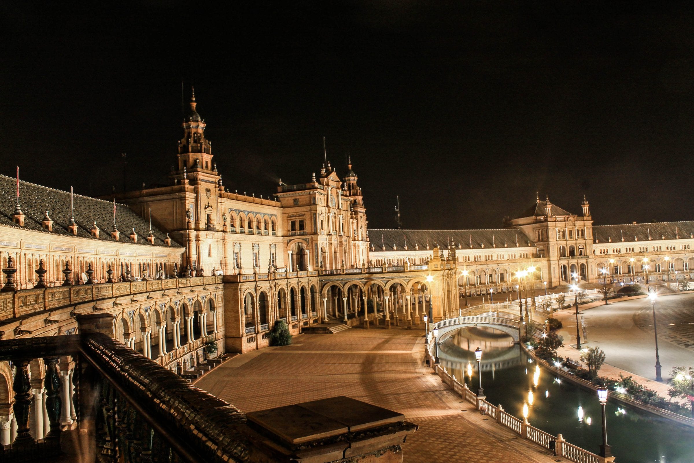 An arcaded square lit up after dark.